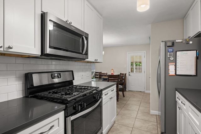 7201 Winchester Rd, North Richland Hills, TX 76182 - kitchen featuring appliances with stainless steel finishes, dark countertops, decorative backsplash, and white cabinets