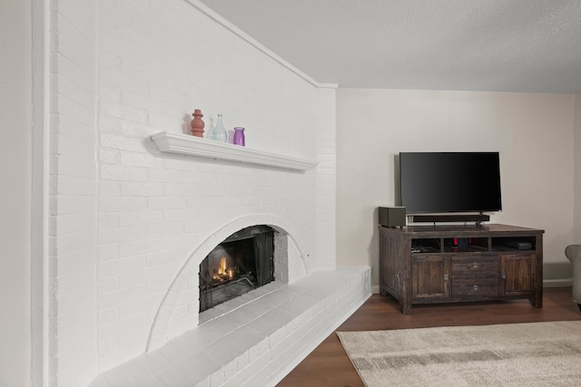 7201 Winchester Rd, North Richland Hills, TX 76182 - living area with wood finished floors, a brick fireplace, and a textured ceiling