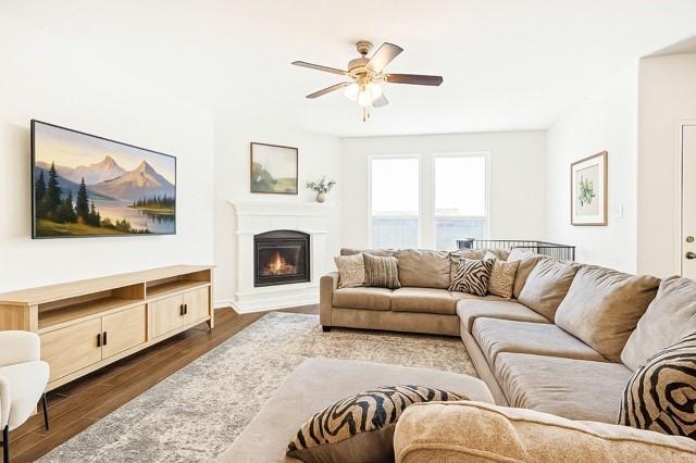 11216 Ponderosa Trl, Aubrey, TX 76227 - living room featuring ceiling fan, dark wood finished floors, and a glass covered fireplace