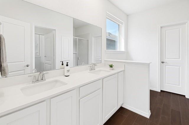11216 Ponderosa Trl, Aubrey, TX 76227 - full bath with double vanity, an enclosed shower, wood finished floors, and baseboards