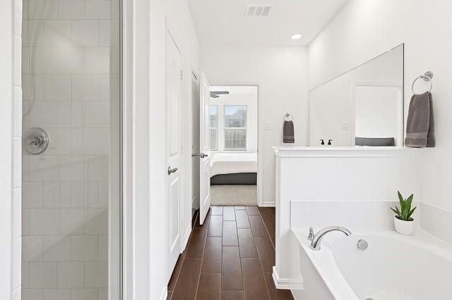 11216 Ponderosa Trl, Aubrey, TX 76227 - full bathroom featuring connected bathroom, a garden tub, tiled shower, wood finished floors, and recessed lighting