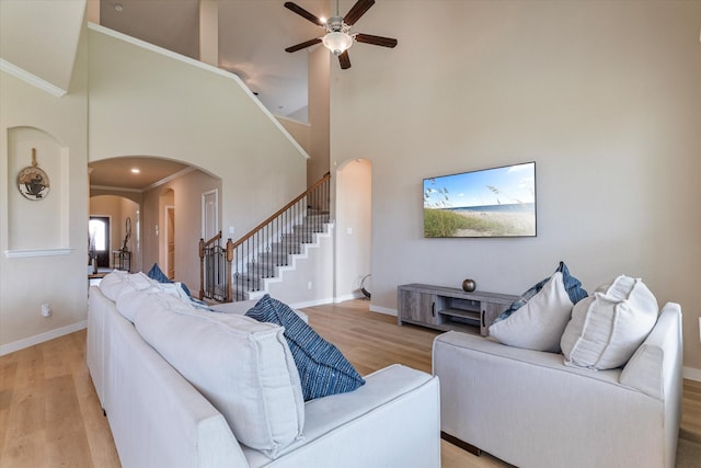4708 River Edge Pl, Frisco, TX 75036 - living room with arched walkways, light wood-type flooring, ceiling fan, stairs, and high vaulted ceiling