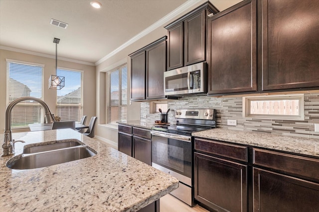 4708 River Edge Pl, Frisco, TX 75036 - kitchen featuring appliances with stainless steel finishes, a sink, crown molding, decorative backsplash, and dark brown cabinets
