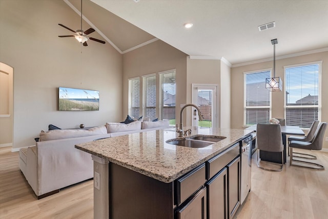 4708 River Edge Pl, Frisco, TX 75036 - kitchen featuring a sink, light wood-style flooring, crown molding, open floor plan, and light stone counters