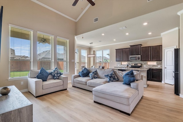 4708 River Edge Pl, Frisco, TX 75036 - living area with ornamental molding, light wood-style flooring, ceiling fan, baseboards, and high vaulted ceiling