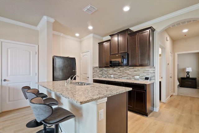 4708 River Edge Pl, Frisco, TX 75036 - kitchen featuring black appliances, a sink, light wood-type flooring, dark brown cabinetry, and crown molding