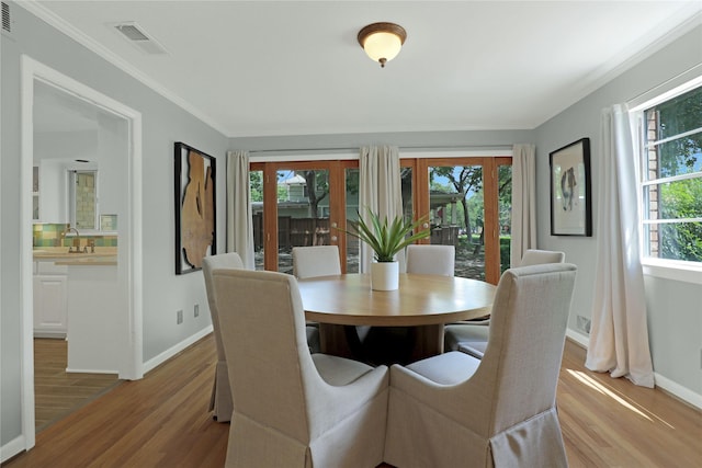 205 N College St, Mckinney, TX 75069 - dining area with baseboards, light wood-style floors, and crown molding
