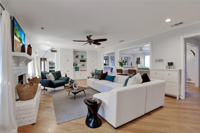 205 N College St, Mckinney, TX 75069 - living area with a ceiling fan, light wood-style flooring, a fireplace, ornamental molding, and recessed lighting