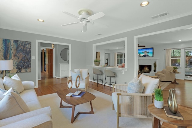 205 N College St, Mckinney, TX 75069 - living area featuring a ceiling fan, wood finished floors, a fireplace, recessed lighting, and crown molding