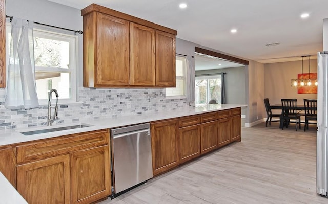 2908 Longfellow Ln, Denton, TX 76209 - kitchen with appliances with stainless steel finishes, a sink, brown cabinets, decorative backsplash, and recessed lighting