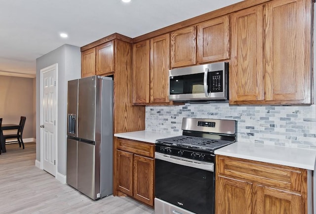 2908 Longfellow Ln, Denton, TX 76209 - kitchen with stainless steel appliances, brown cabinetry, backsplash, light wood finished floors, and recessed lighting