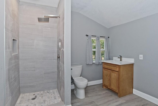 2908 Longfellow Ln, Denton, TX 76209 - full bath featuring vaulted ceiling, a tile shower, vanity, toilet, and wood finished floors