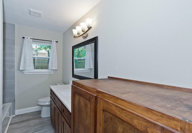 2908 Longfellow Ln, Denton, TX 76209 - bathroom with vanity, baseboards, toilet, wood finished floors, and a chandelier