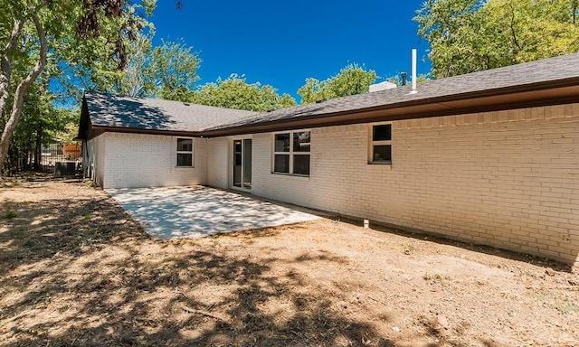 2908 Longfellow Ln, Denton, TX 76209 - rear view of house featuring brick siding, cooling unit, a patio area, and roof with shingles