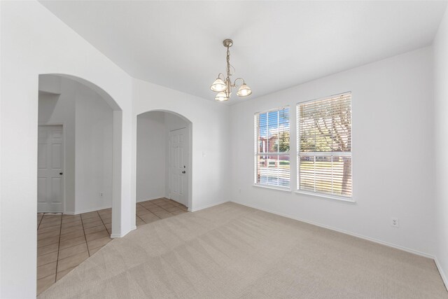2442 Mackinac Dr, Frisco, TX 75033 - carpeted spare room featuring a chandelier, arched walkways, baseboards, and tile patterned floors