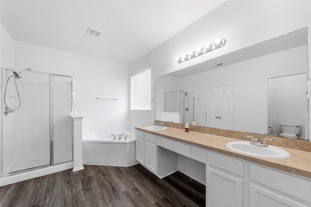 2442 Mackinac Dr, Frisco, TX 75033 - bathroom featuring a bath, a stall shower, wood finished floors, and double vanity