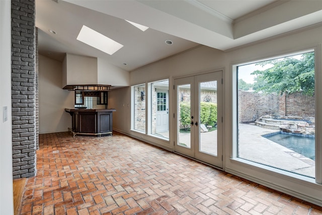 18602 Turnbridge Dr, Dallas, TX 75252 - unfurnished living room featuring a skylight, brick floors, crown molding, french doors, and bar area