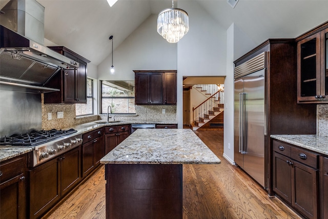 18602 Turnbridge Dr, Dallas, TX 75252 - kitchen featuring appliances with stainless steel finishes, light wood-type flooring, wall chimney exhaust hood, high vaulted ceiling, and a sink