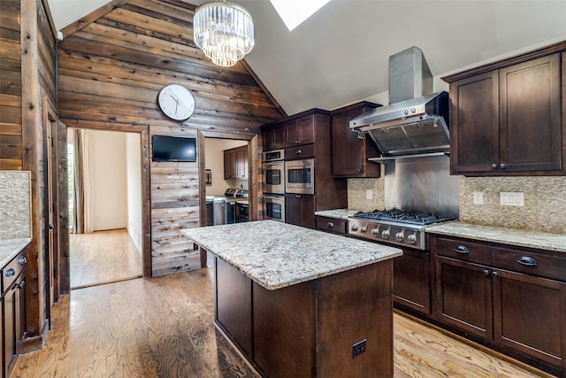 18602 Turnbridge Dr, Dallas, TX 75252 - kitchen featuring separate washer and dryer, vaulted ceiling, appliances with stainless steel finishes, light wood-type flooring, and a kitchen island