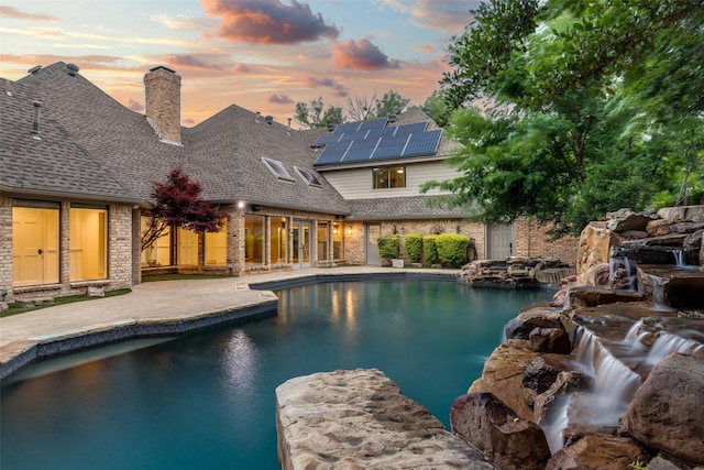 18602 Turnbridge Dr, Dallas, TX 75252 - pool at dusk featuring an outdoor pool and a patio area