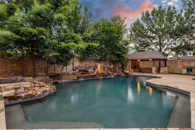 18602 Turnbridge Dr, Dallas, TX 75252 - pool at dusk featuring a patio area and a gazebo
