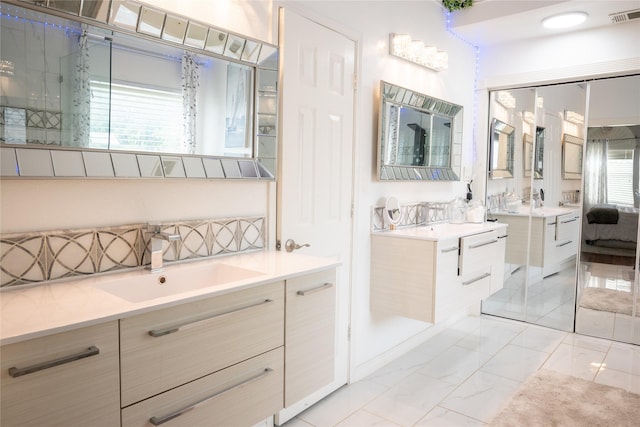 1421 Eugene Dr, Wylie, TX 75098 - full bathroom with two vanities, healthy amount of natural light, marble finish flooring, and tasteful backsplash