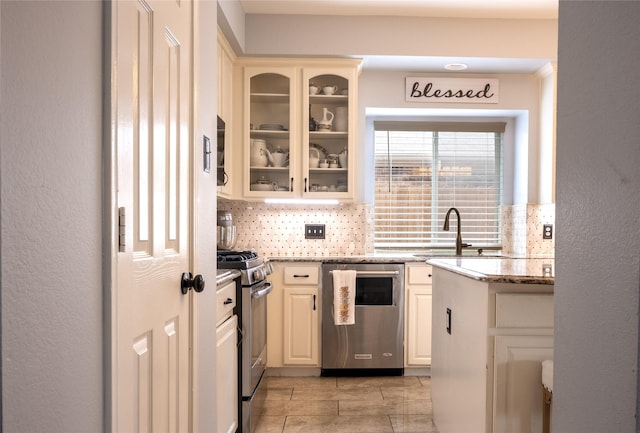 1421 Eugene Dr, Wylie, TX 75098 - kitchen featuring stainless steel appliances, a sink, tasteful backsplash, and glass insert cabinets
