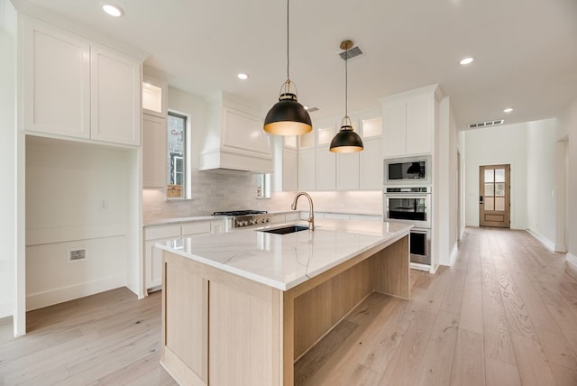 3340 Crescent Ln, Celina, TX 75009 - kitchen with appliances with stainless steel finishes, light wood-style floors, decorative backsplash, custom exhaust hood, and recessed lighting