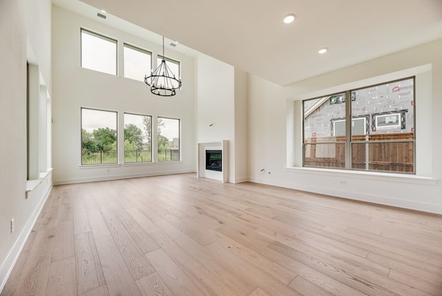 3340 Crescent Ln, Celina, TX 75009 - unfurnished living room with light wood-style flooring, a chandelier, plenty of natural light, recessed lighting, and a high ceiling