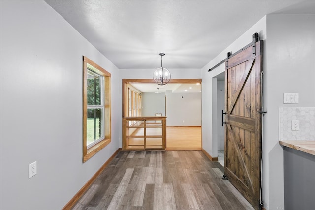 1317 Elby St, Irving, TX 75061 - hall with a barn door, wood finished floors, and baseboards