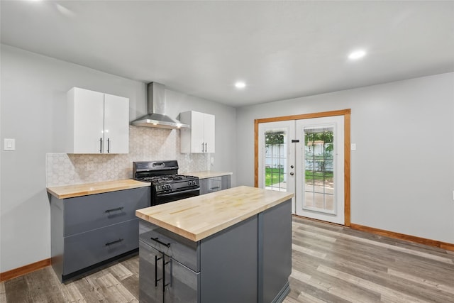 1317 Elby St, Irving, TX 75061 - kitchen with butcher block counters, wall chimney exhaust hood, black gas stove, gray cabinetry, and recessed lighting