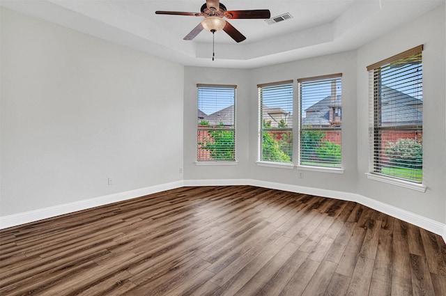 2353 Salisbury Ct, The Colony, TX 75056 - unfurnished room featuring dark wood finished floors, a ceiling fan, a tray ceiling, and baseboards
