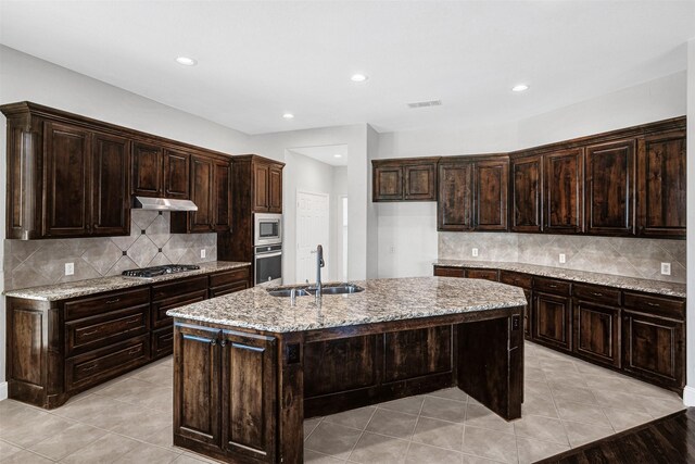 2353 Salisbury Ct, The Colony, TX 75056 - kitchen with appliances with stainless steel finishes, a sink, tasteful backsplash, light stone countertops, and recessed lighting