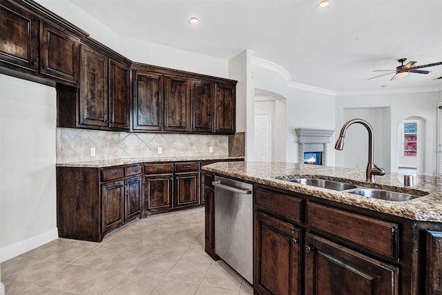 2353 Salisbury Ct, The Colony, TX 75056 - kitchen with stainless steel dishwasher, a sink, arched walkways, a ceiling fan, and light stone countertops