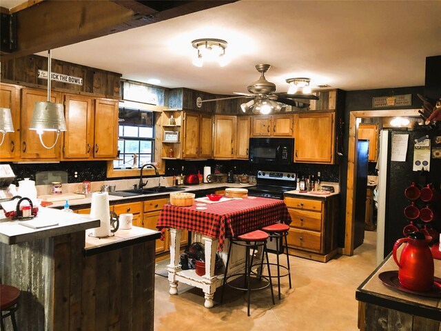 783 County Rd 4420, Whitewright, TX 75491 - kitchen featuring black microwave, stainless steel electric range oven, a sink, freestanding refrigerator, and brown cabinetry