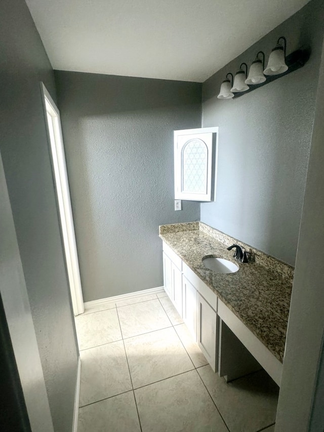 826 E Center St, Duncanville, TX 75116 - bathroom with vanity, a textured wall, tile patterned floors, and baseboards