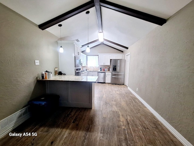 826 E Center St, Duncanville, TX 75116 - kitchen with appliances with stainless steel finishes, a textured wall, hardwood / wood-style floors, white cabinets, and a peninsula