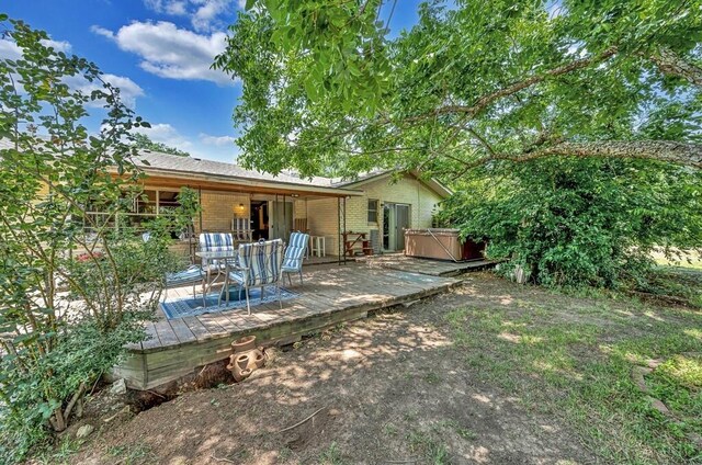 1700 Sunset Rd, Robinson, TX 76706 - rear view of house featuring a hot tub, brick siding, a wooden deck, and outdoor dining area