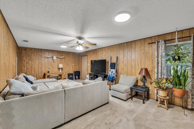 1313 Crow Dr, Waco, TX 76705 - carpeted living area featuring ceiling fan, wood walls, and a textured ceiling