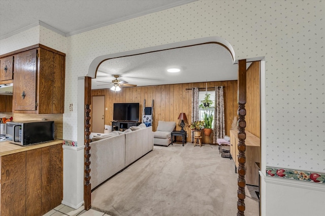 1313 Crow Dr, Waco, TX 76705 - living room with wallpapered walls, ornamental molding, ceiling fan, a textured ceiling, and arched walkways
