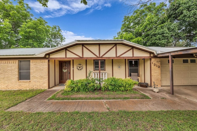 1313 Crow Dr, Waco, TX 76705 - view of front of house featuring an attached garage, concrete driveway, stucco siding, covered porch, and metal roof