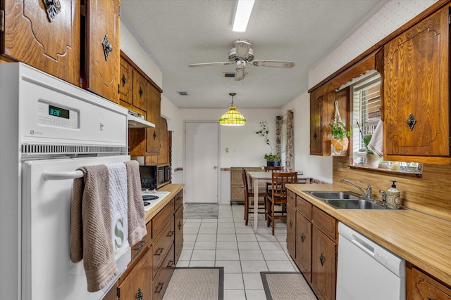 1313 Crow Dr, Waco, TX 76705 - kitchen featuring white appliances, a sink, brown cabinets, light countertops, and a ceiling fan