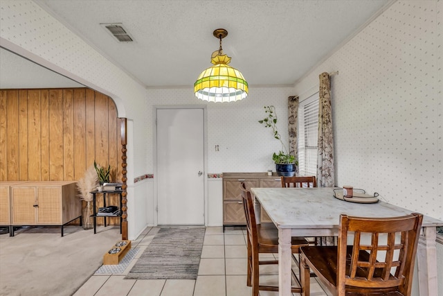 1313 Crow Dr, Waco, TX 76705 - dining space with wallpapered walls, a textured ceiling, light tile patterned floors, and arched walkways