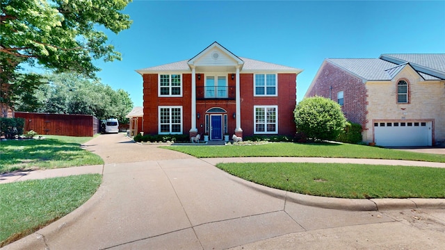 7534 Wellesley Ave, Garland, TX 75044 - neoclassical / greek revival house with a front yard, concrete driveway, a garage, and brick siding