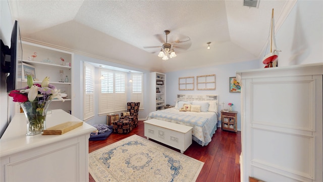 7534 Wellesley Ave, Garland, TX 75044 - bedroom featuring dark wood-type flooring, a raised ceiling, a ceiling fan, a textured ceiling, and crown molding