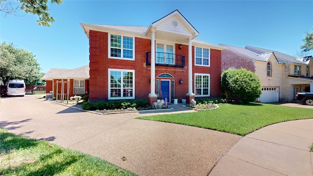 7534 Wellesley Ave, Garland, TX 75044 - neoclassical home with driveway, a front yard, brick siding, and a balcony