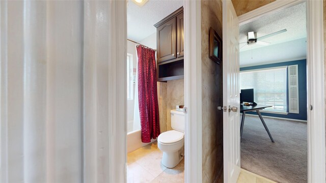 7534 Wellesley Ave, Garland, TX 75044 - full bathroom with toilet, a textured ceiling, shower / bathtub combination with curtain, a ceiling fan, and baseboards