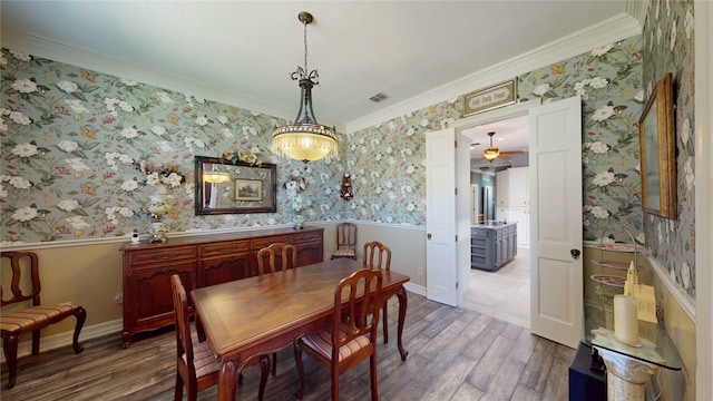 7534 Wellesley Ave, Garland, TX 75044 - dining space with wallpapered walls, a wainscoted wall, wood finished floors, ornamental molding, and a ceiling fan