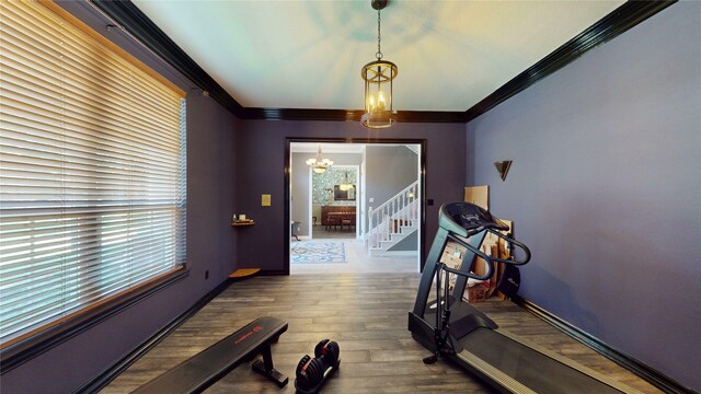 7534 Wellesley Ave, Garland, TX 75044 - workout area with a chandelier, wood finished floors, ornamental molding, and baseboards