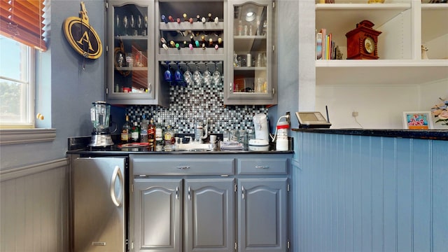 7534 Wellesley Ave, Garland, TX 75044 - indoor dry bar with freestanding refrigerator, wainscoting, and tasteful backsplash